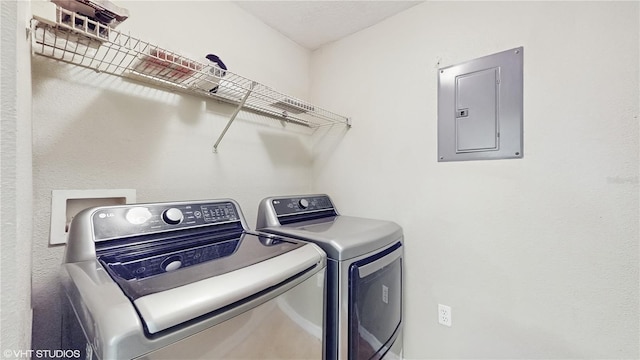 clothes washing area with washer and dryer, electric panel, and laundry area