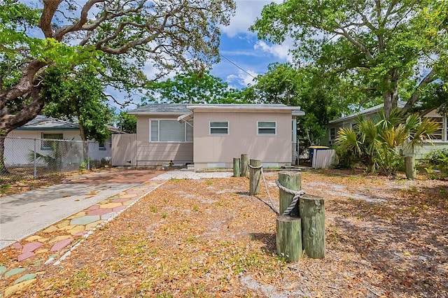 rear view of property with fence and driveway