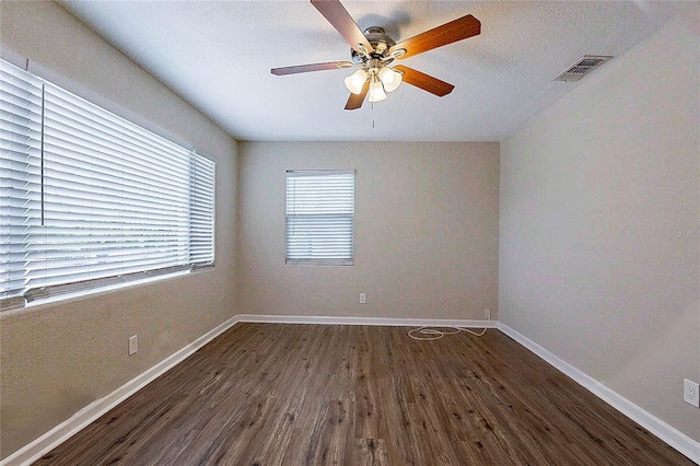 empty room with visible vents, baseboards, ceiling fan, and wood finished floors