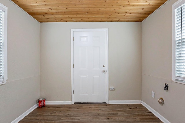 clothes washing area featuring baseboards, wood ceiling, and wood finished floors