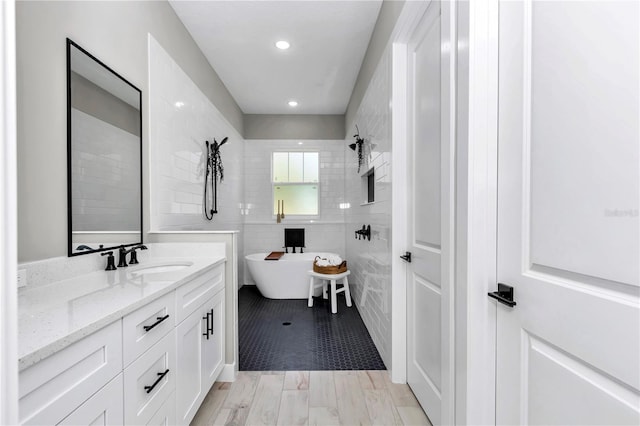 6725 SW 131st Cir, Ocala, FL 34481 - full bathroom with vanity, recessed lighting, a freestanding tub, and tile walls