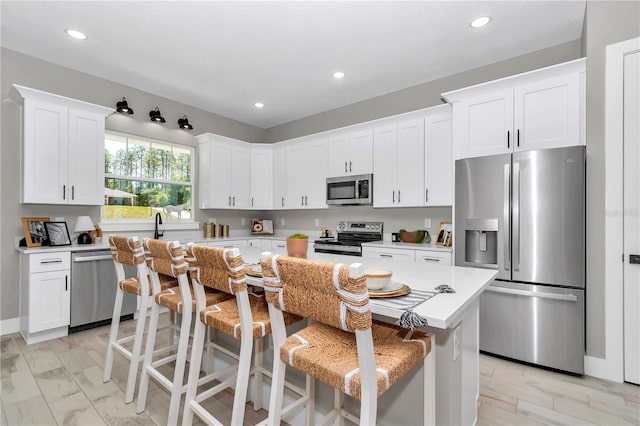 6725 SW 131st Cir, Ocala, FL 34481 - kitchen featuring white cabinets, light countertops, a kitchen breakfast bar, stainless steel appliances, and a kitchen island