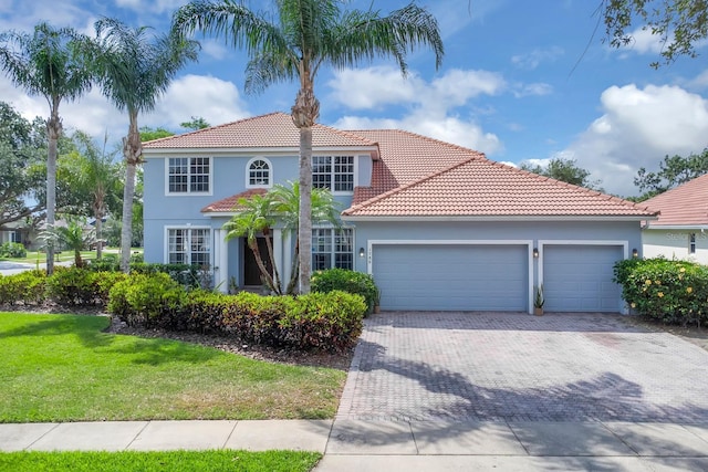 1786 Lee Janzen Dr, Kissimmee, FL 34744 - mediterranean / spanish-style home with stucco siding, decorative driveway, a tile roof, and a garage