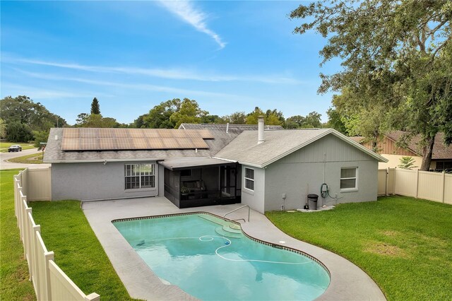 819 Haulover Dr, Altamonte Springs, FL 32714 - back of house with a sunroom, roof with shingles, roof mounted solar panels, a patio area, and stucco siding