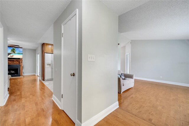 819 Haulover Dr, Altamonte Springs, FL 32714 - hall with light wood-style floors, a textured ceiling, and baseboards