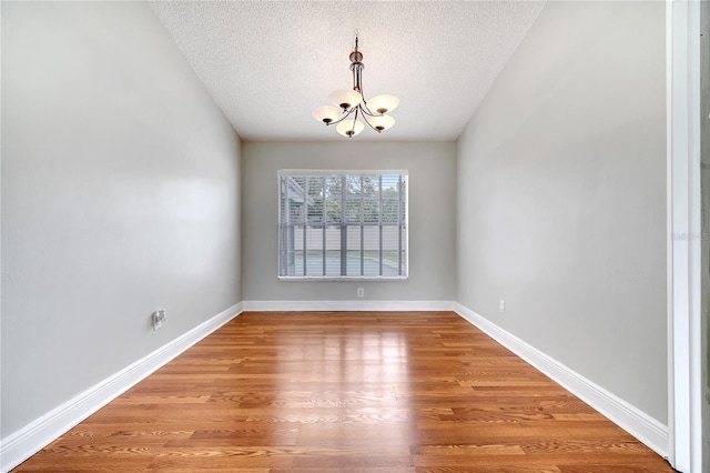 819 Haulover Dr, Altamonte Springs, FL 32714 - unfurnished room featuring a chandelier, a textured ceiling, wood finished floors, and baseboards
