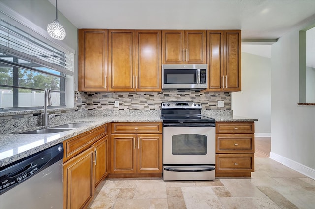 819 Haulover Dr, Altamonte Springs, FL 32714 - kitchen with appliances with stainless steel finishes, a sink, baseboards, and brown cabinetry