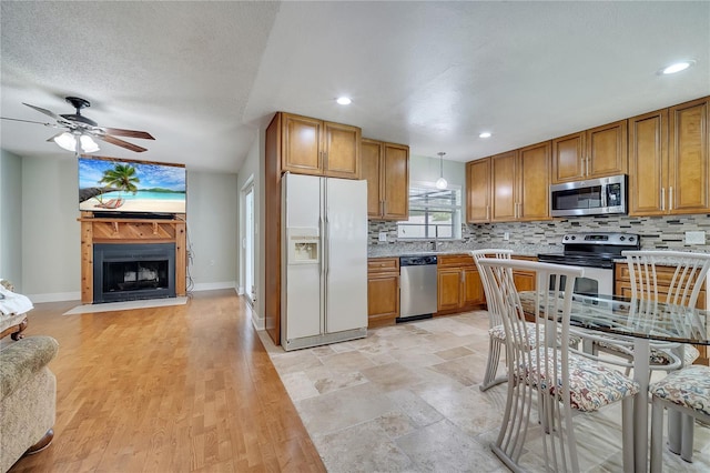 819 Haulover Dr, Altamonte Springs, FL 32714 - kitchen featuring stainless steel appliances, brown cabinetry, backsplash, and recessed lighting