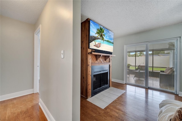 819 Haulover Dr, Altamonte Springs, FL 32714 - unfurnished living room with wood finished floors, a large fireplace, a textured ceiling, and baseboards