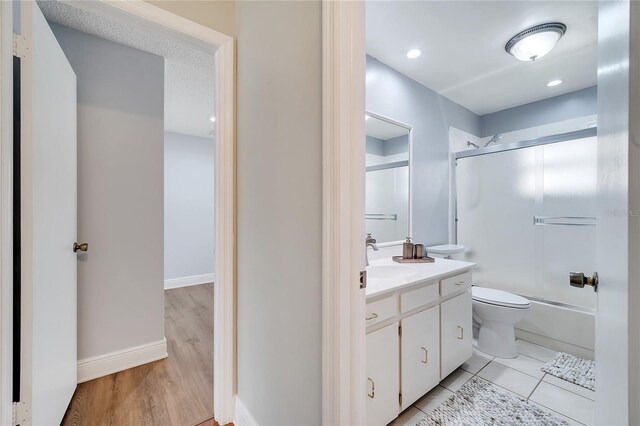 819 Haulover Dr, Altamonte Springs, FL 32714 - full bath with toilet, vanity, combined bath / shower with glass door, wood finished floors, and baseboards