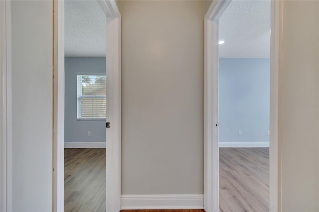 819 Haulover Dr, Altamonte Springs, FL 32714 - hallway with a textured ceiling, wood finished floors, and baseboards