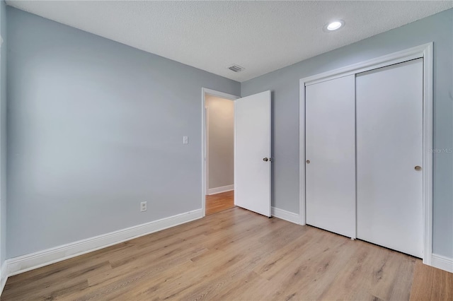 819 Haulover Dr, Altamonte Springs, FL 32714 - unfurnished bedroom featuring wood finished floors, baseboards, a textured ceiling, a closet, and recessed lighting