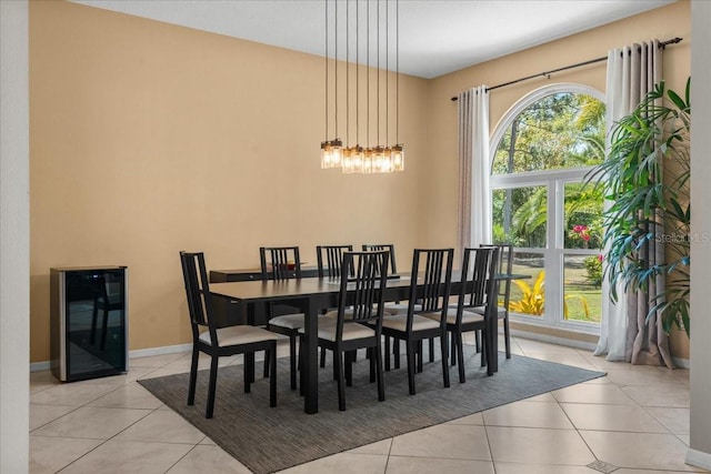 dining room with light tile patterned floors, an inviting chandelier, baseboards, and beverage cooler