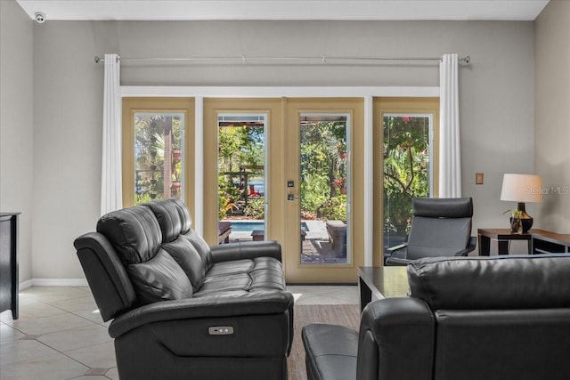 living area with baseboards, light tile patterned floors, and french doors