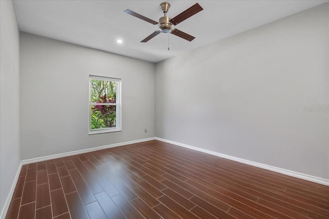 unfurnished room featuring a ceiling fan, dark wood finished floors, and baseboards