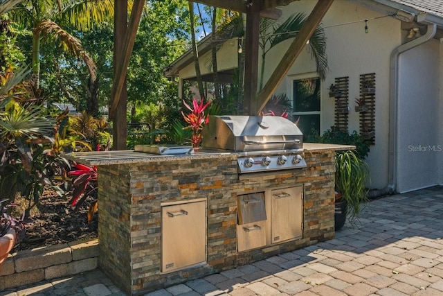 view of patio featuring exterior kitchen and a grill