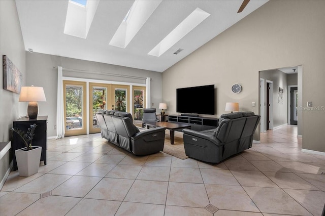 living room with a skylight, light tile patterned floors, baseboards, high vaulted ceiling, and french doors