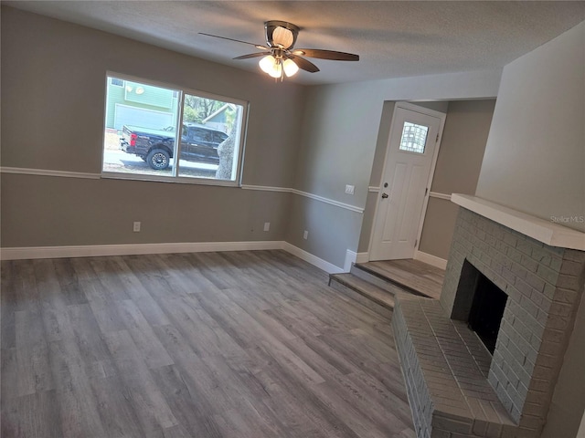 unfurnished living room featuring wood finished floors, a healthy amount of sunlight, a ceiling fan, and baseboards