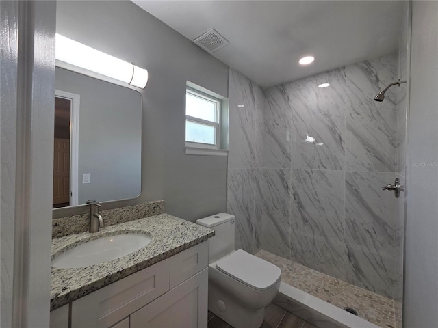 full bathroom featuring recessed lighting, visible vents, toilet, vanity, and a marble finish shower