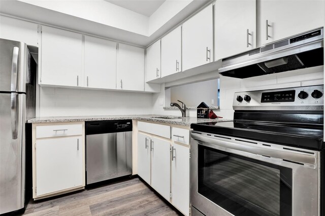 516 Polaris Loop Unit 110, Casselberry, FL 32707 - kitchen with light wood-type flooring, white cabinetry, tasteful backsplash, a sink, and stainless steel appliances