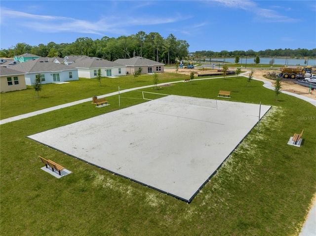 surrounding community featuring a yard, volleyball court, and a water view