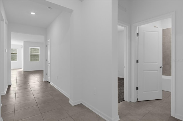 hall with baseboards, tile patterned floors, and recessed lighting