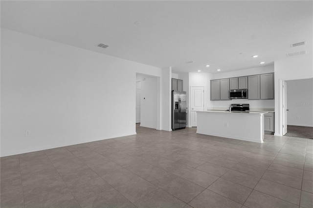 unfurnished living room with tile patterned floors, visible vents, and recessed lighting