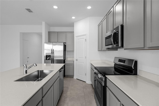 kitchen with recessed lighting, stainless steel appliances, visible vents, a sink, and gray cabinetry