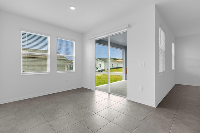 empty room with baseboards, tile patterned flooring, and recessed lighting
