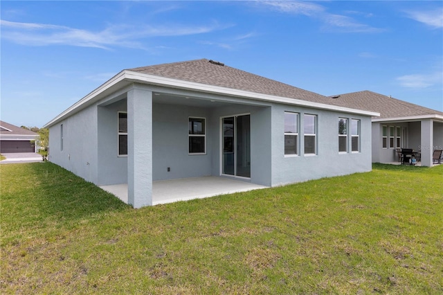 back of house with a patio area, a lawn, roof with shingles, and stucco siding
