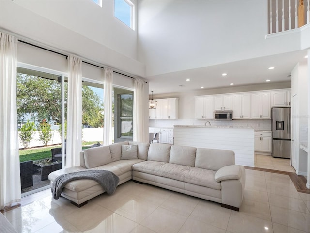 living room featuring light tile patterned floors, a high ceiling, and recessed lighting