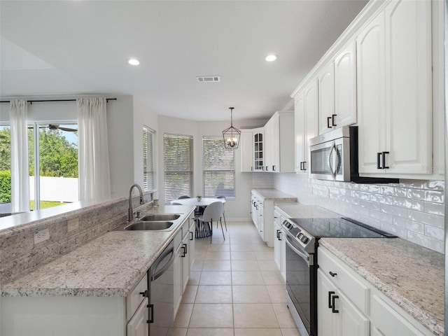 kitchen with appliances with stainless steel finishes, a sink, visible vents, and a healthy amount of sunlight