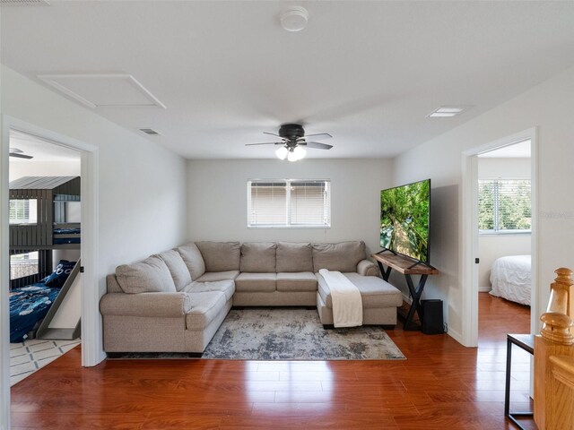 living room featuring attic access, a ceiling fan, wood finished floors, and visible vents