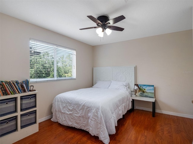 bedroom featuring ceiling fan, baseboards, and wood finished floors