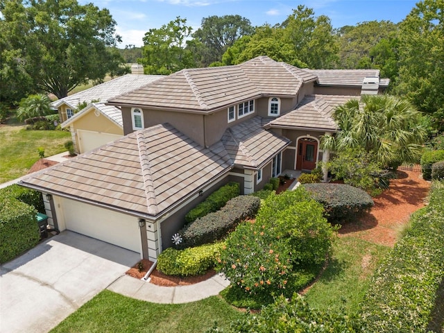 14037 Fairway Willow Ln, Winter Garden, FL 34787 - view of front of house featuring stucco siding, a chimney, concrete driveway, and an attached garage