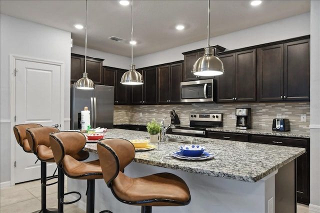 3806 Lana Ave, Davenport, FL 33897 - kitchen with appliances with stainless steel finishes, backsplash, decorative light fixtures, dark brown cabinetry, and recessed lighting