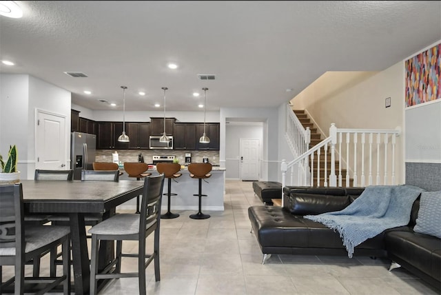 3806 Lana Ave, Davenport, FL 33897 - dining space featuring light tile patterned floors, a textured ceiling, recessed lighting, and stairway