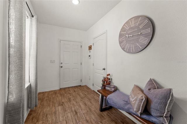 doorway featuring baseboards and wood finished floors