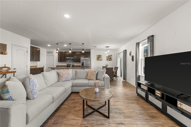 living room with recessed lighting, baseboards, and wood finished floors