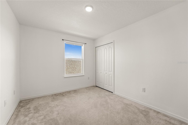 unfurnished bedroom featuring carpet floors, baseboards, and a closet