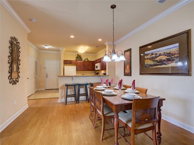 dining area with crown molding, an inviting chandelier, light wood-style flooring, recessed lighting, and baseboards