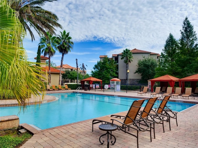 community pool featuring a gazebo, fence, and a patio area