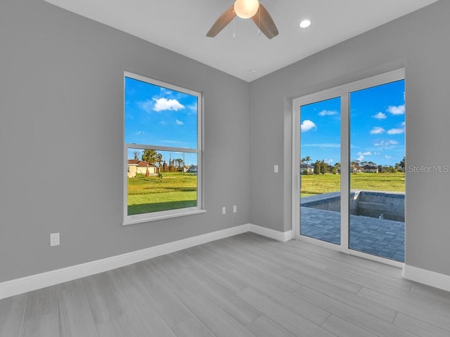 spare room with baseboards, wood finished floors, recessed lighting, and ceiling fan
