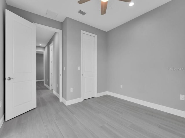 unfurnished bedroom with baseboards, wood finished floors, visible vents, and recessed lighting