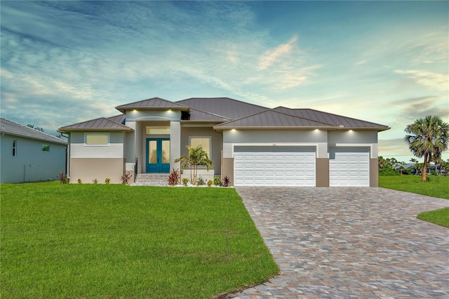 211 Rotonda Blvd S, Rotonda West, FL 33947 - prairie-style house featuring a standing seam roof, a metal roof, a front yard, driveway, and an attached garage