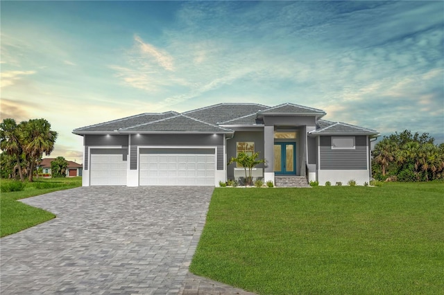 193 Rotonda Blvd S, Rotonda West, FL 33947 - prairie-style home with an attached garage, a front lawn, decorative driveway, a tile roof, and stucco siding