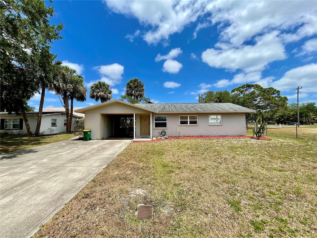 ranch-style house featuring concrete driveway and a front lawn