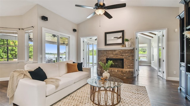 living room with baseboards, a wealth of natural light, a brick fireplace, and dark wood-style floors