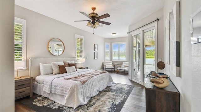 bedroom featuring access to outside, dark wood-style flooring, and ceiling fan