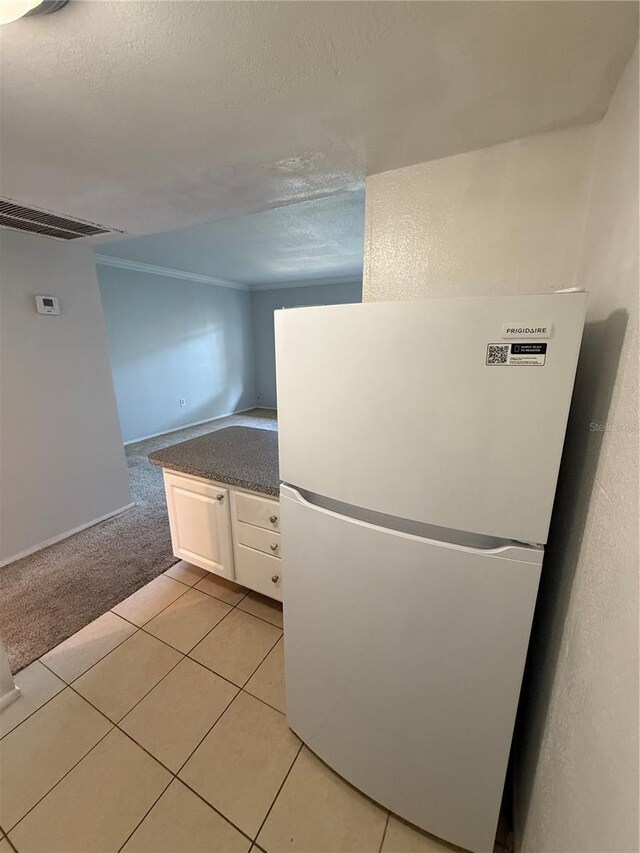 131 Water Front Way Unit 110, Altamonte Springs, FL 32701 - kitchen with freestanding refrigerator, light carpet, baseboards, white cabinetry, and light tile patterned floors